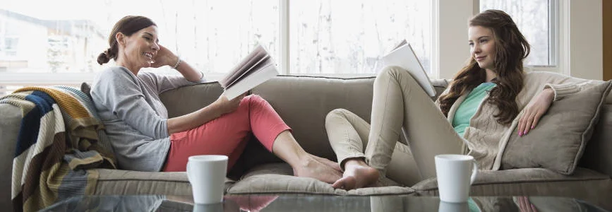 Zwei Personen lesen auf dem Sofa